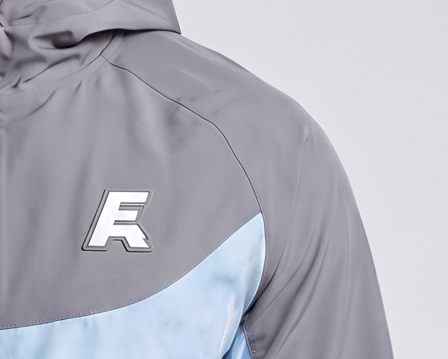 Close detail of the raised rubber emblem on the Aurora jacket chest